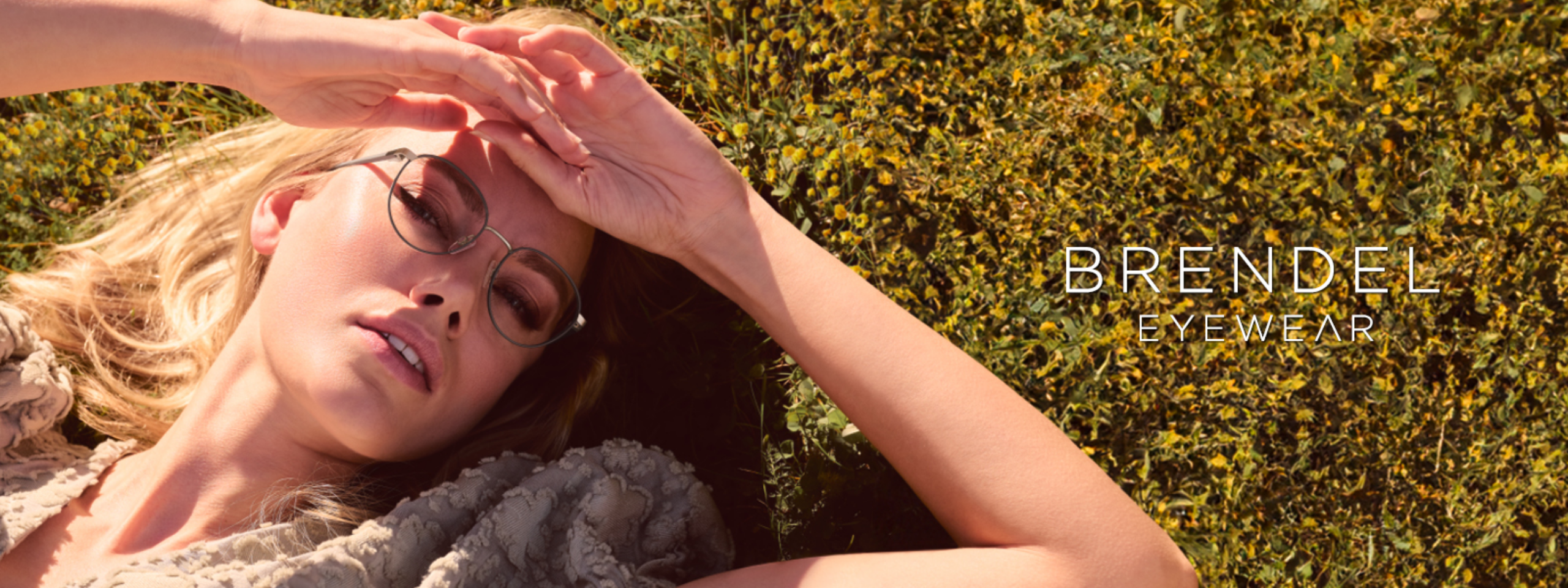 Brendel: Frau mit Brille liegt im Gras